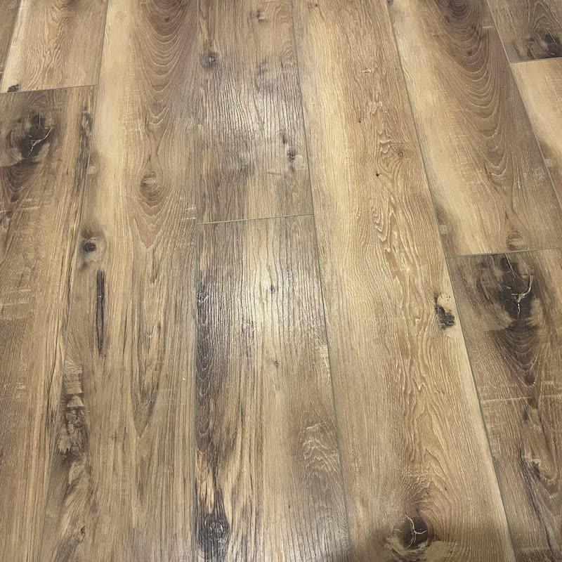 Close-up of laid wide-plank flooring with heavy knots and dark grain.